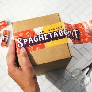 a guy using sticker tape to close a box